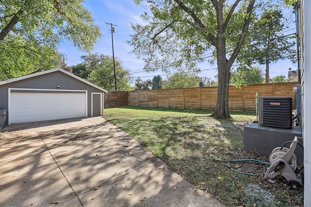 view of yard with central air condition unit, an outbuilding, and a garage