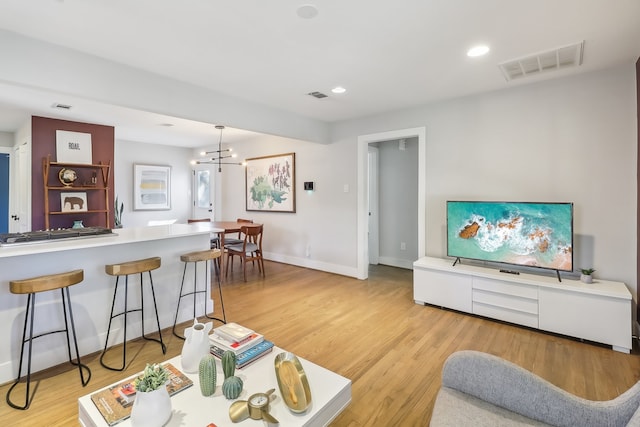 living room featuring a notable chandelier and light hardwood / wood-style floors