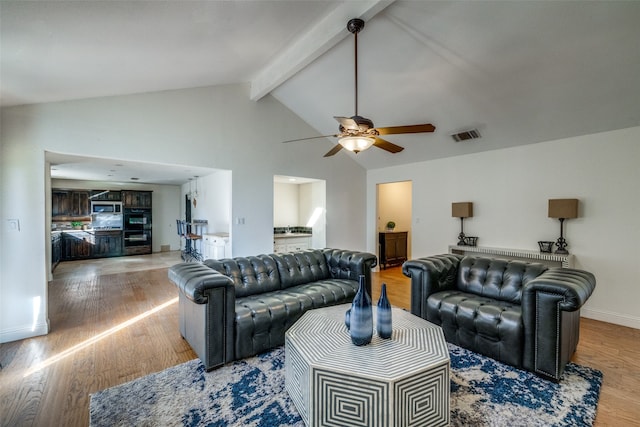 living room with beamed ceiling, wood-type flooring, high vaulted ceiling, and ceiling fan