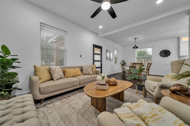 living room featuring hardwood / wood-style floors, ceiling fan, and beam ceiling