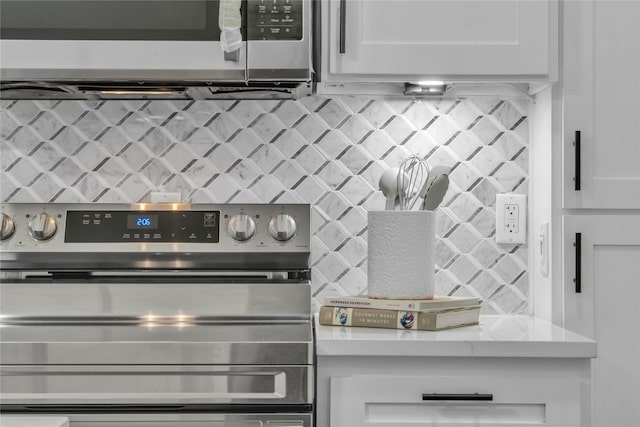 kitchen with white cabinets, wall oven, tasteful backsplash, and light stone counters