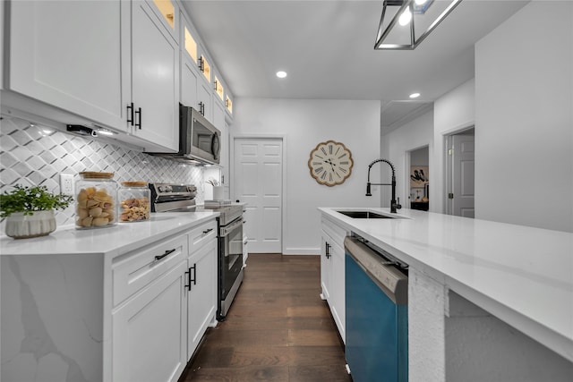 kitchen with backsplash, dark wood-type flooring, sink, white cabinetry, and stainless steel appliances