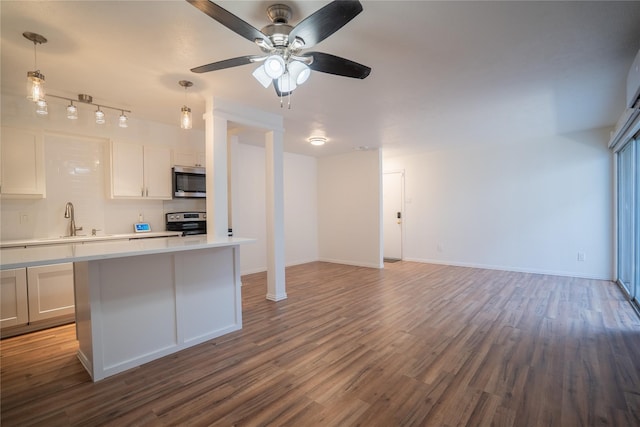 kitchen featuring sink, stainless steel appliances, pendant lighting, white cabinets, and hardwood / wood-style flooring