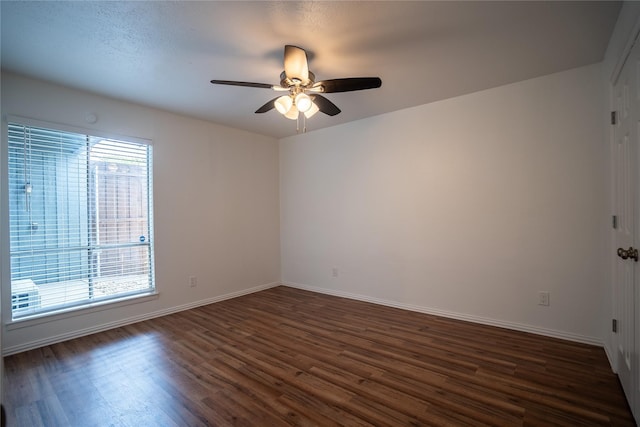 spare room with dark hardwood / wood-style floors and ceiling fan