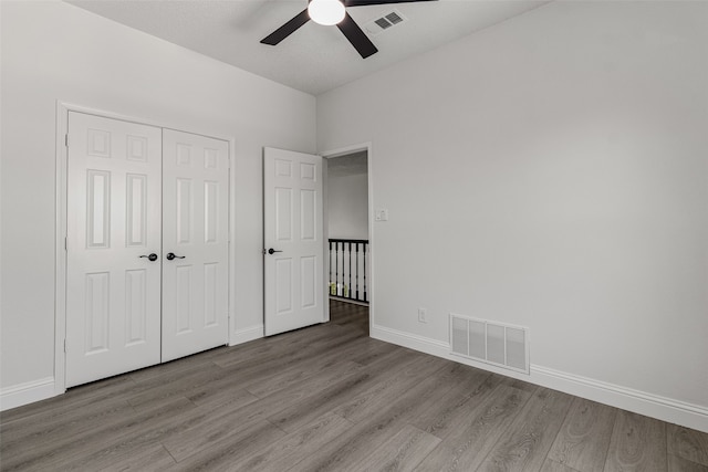 unfurnished bedroom featuring a closet, light hardwood / wood-style flooring, and ceiling fan