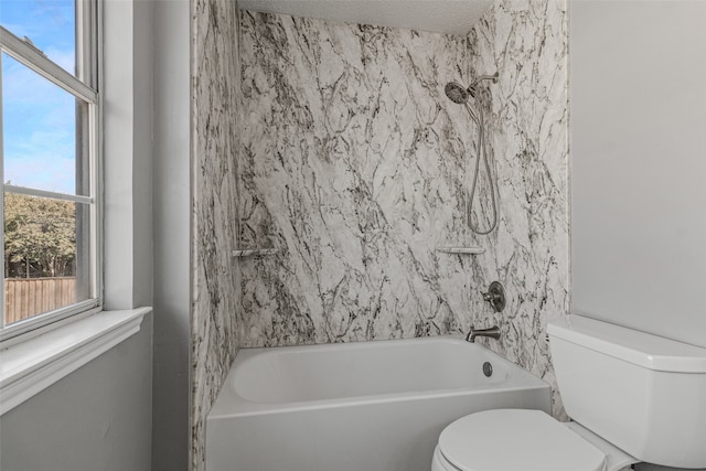 bathroom with shower / bathing tub combination, toilet, and a textured ceiling