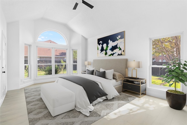 bedroom with light hardwood / wood-style flooring, vaulted ceiling, and ceiling fan