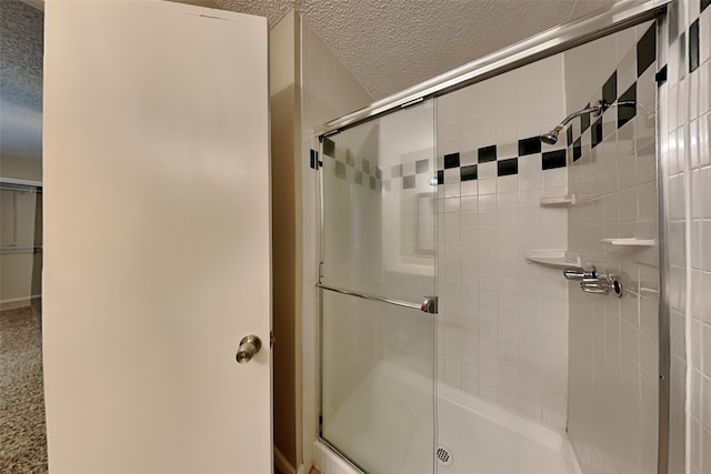 bathroom with an enclosed shower and a textured ceiling