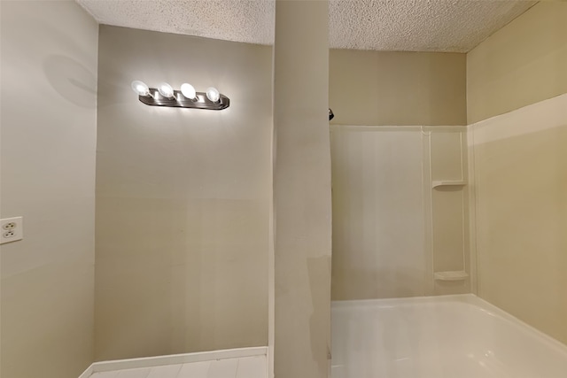 bathroom with shower / bath combination and a textured ceiling