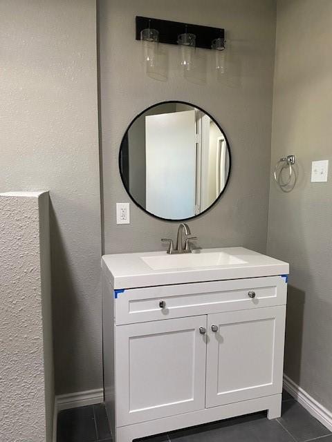 bathroom featuring tile patterned flooring, vanity, and baseboards