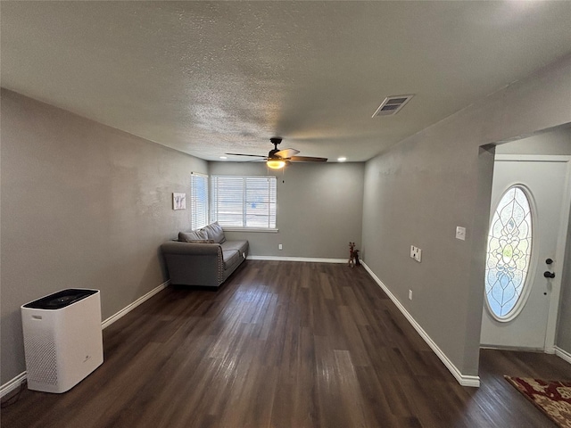 interior space with dark wood-style floors, visible vents, and baseboards