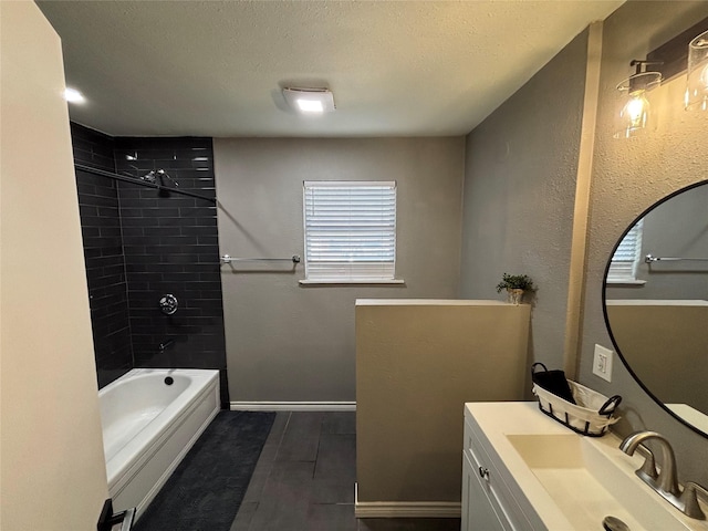 bathroom featuring a textured ceiling, bathtub / shower combination, wood finish floors, vanity, and baseboards