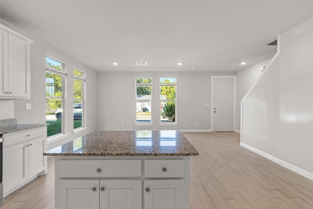 kitchen featuring a wealth of natural light, a kitchen island, and light hardwood / wood-style floors