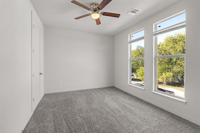 carpeted spare room featuring ceiling fan