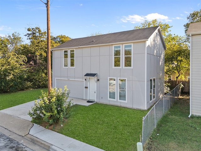 view of property featuring a front yard and a garage