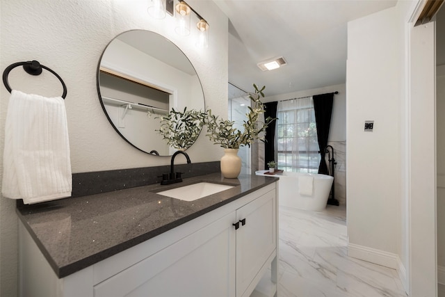 bathroom featuring vanity and a tub