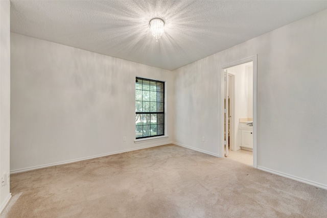 carpeted empty room with a textured ceiling