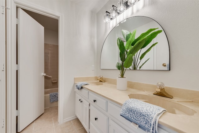 bathroom with tile patterned floors, vanity, and tiled shower / bath combo