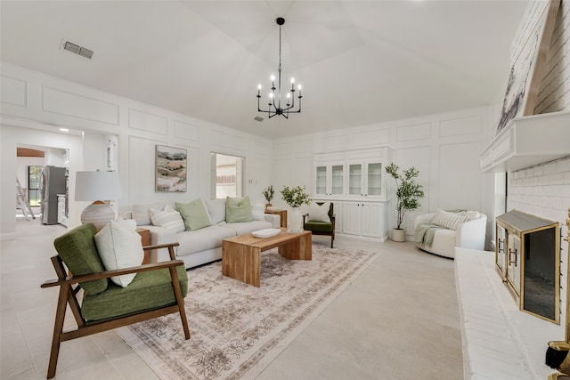 living room featuring a fireplace, an inviting chandelier, lofted ceiling, and light tile patterned flooring