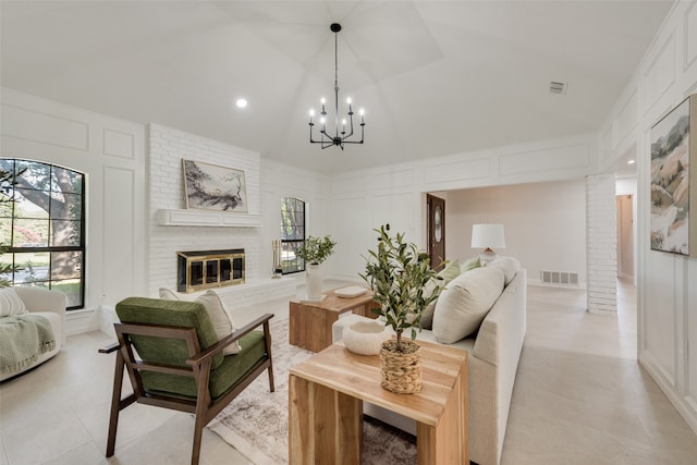 living room with vaulted ceiling, a fireplace, and a chandelier