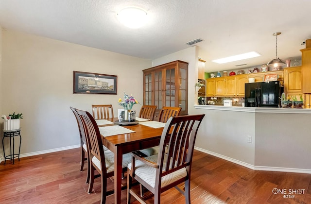 dining room featuring hardwood / wood-style floors and a textured ceiling