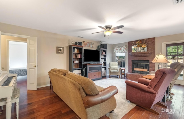 living room with ceiling fan, dark hardwood / wood-style flooring, and a fireplace