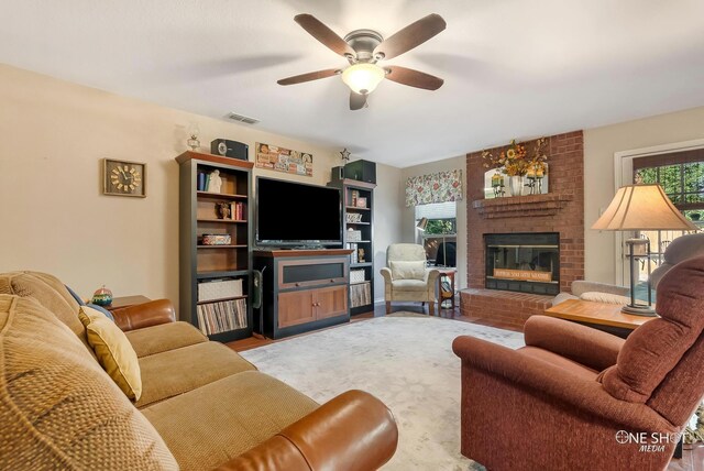 living room featuring a fireplace and ceiling fan