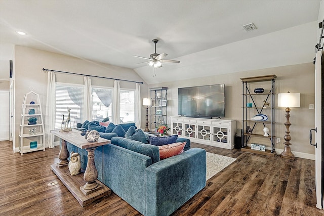 living room featuring a barn door, ceiling fan, dark hardwood / wood-style floors, and vaulted ceiling