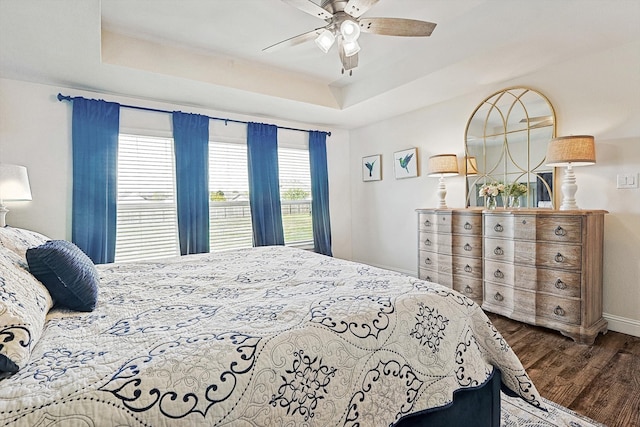 bedroom featuring a raised ceiling, ceiling fan, and hardwood / wood-style flooring