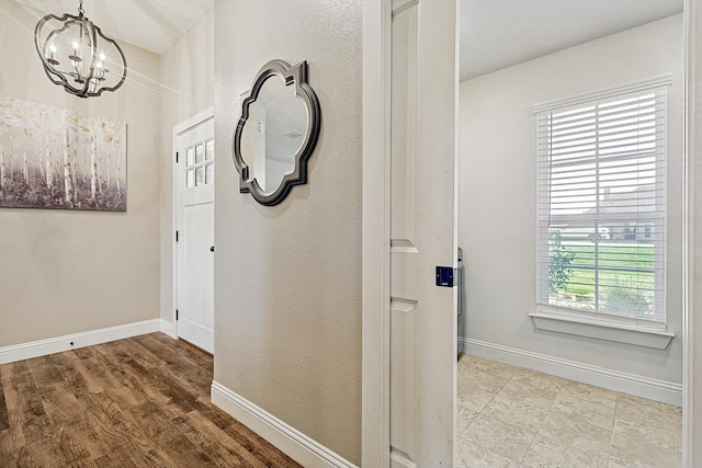 hall with light hardwood / wood-style floors and an inviting chandelier