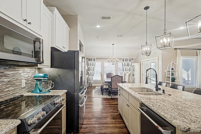 kitchen with sink, dark hardwood / wood-style flooring, backsplash, an island with sink, and appliances with stainless steel finishes