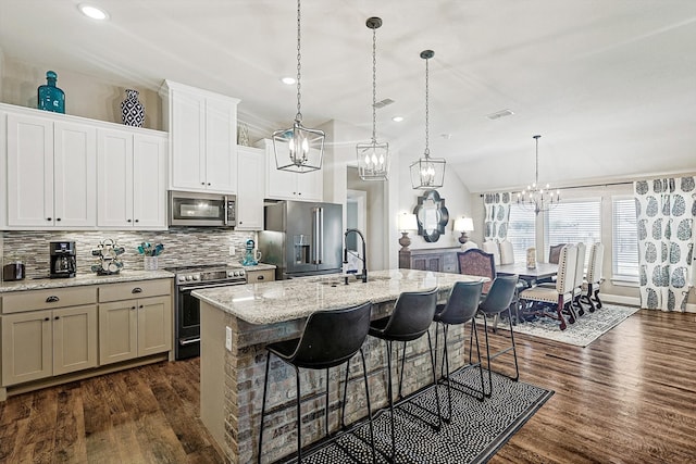 kitchen featuring a breakfast bar, a kitchen island with sink, sink, dark hardwood / wood-style flooring, and stainless steel appliances