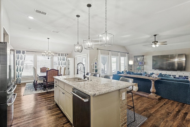 kitchen with a center island with sink, sink, vaulted ceiling, dark hardwood / wood-style floors, and appliances with stainless steel finishes