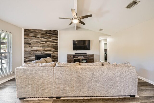 living room with ceiling fan, a fireplace, dark wood-type flooring, and vaulted ceiling