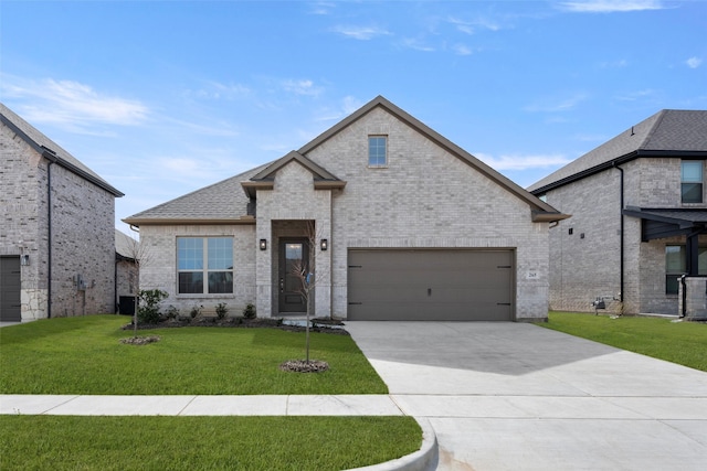 french country style house featuring brick siding, concrete driveway, a front lawn, and roof with shingles