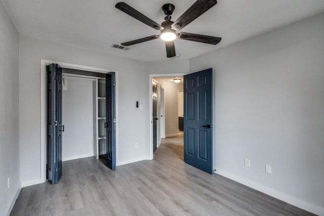 unfurnished bedroom featuring ceiling fan, light wood-type flooring, and a closet