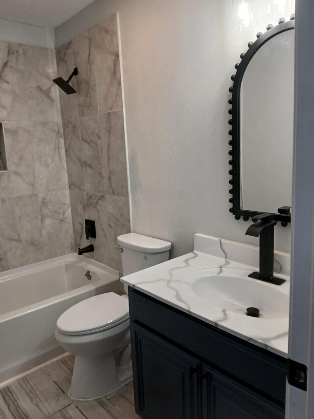 full bathroom with tiled shower / bath combo, vanity, and toilet