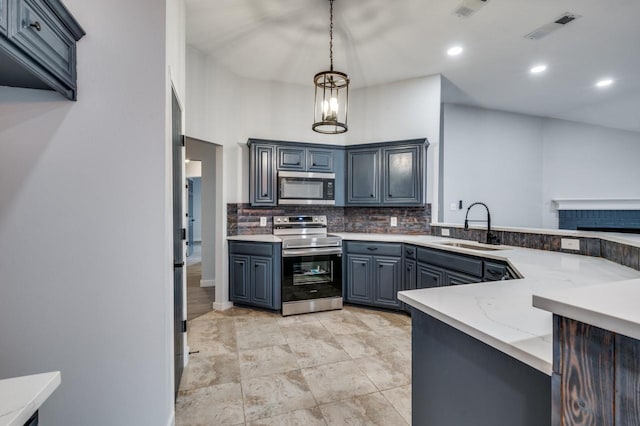 kitchen featuring sink, hanging light fixtures, gray cabinets, light stone counters, and stainless steel appliances