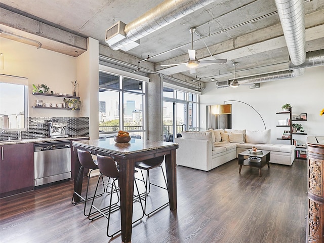 kitchen with light stone countertops, appliances with stainless steel finishes, and dark hardwood / wood-style floors