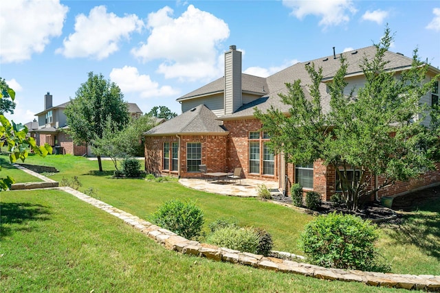 rear view of house featuring a yard and a patio area