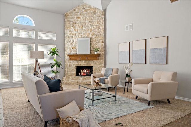 carpeted living room with a fireplace and high vaulted ceiling