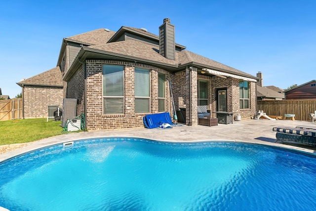 back of house with a fenced in pool and a patio