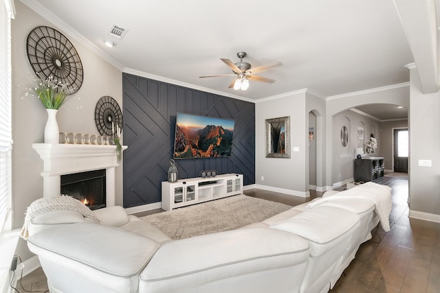 living room with crown molding, dark hardwood / wood-style floors, and ceiling fan