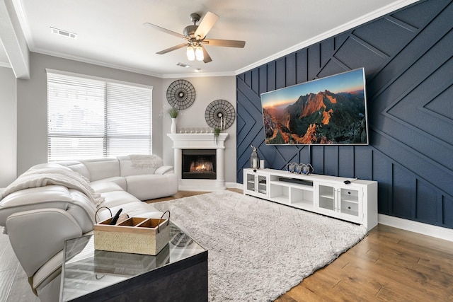 living room featuring hardwood / wood-style flooring, ornamental molding, and ceiling fan