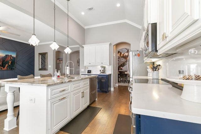 kitchen featuring hanging light fixtures, a breakfast bar area, white cabinets, and a center island with sink