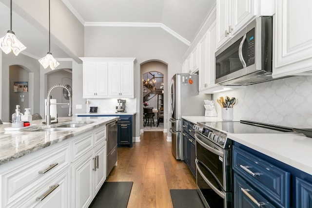 kitchen with white cabinetry, sink, ornamental molding, stainless steel appliances, and blue cabinetry