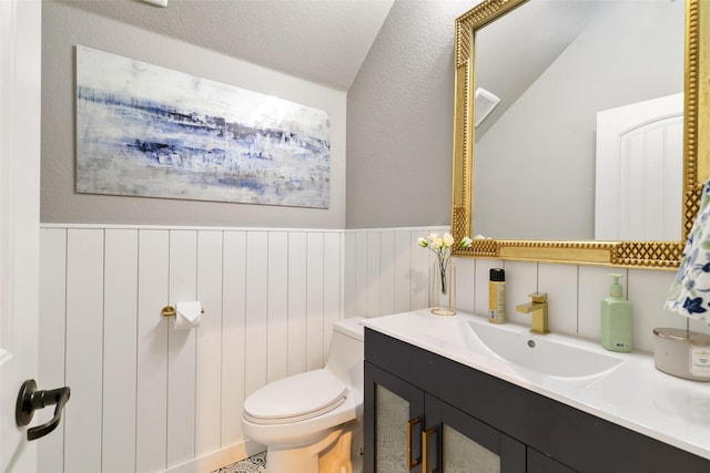 bathroom featuring vanity, a textured ceiling, vaulted ceiling, and toilet