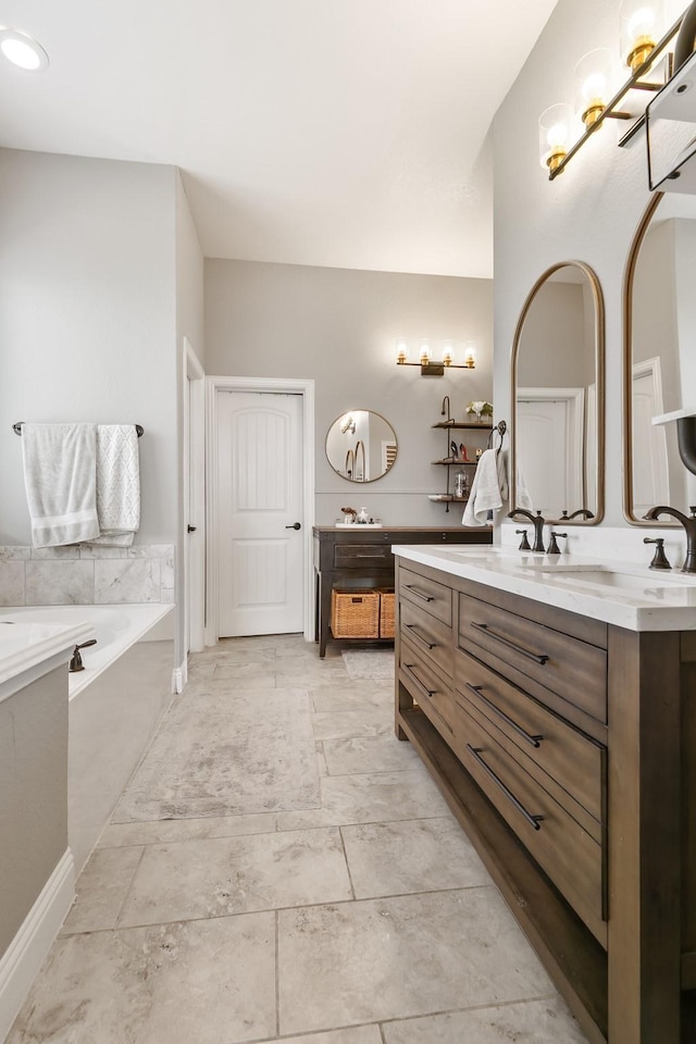 bathroom with vanity and tiled tub