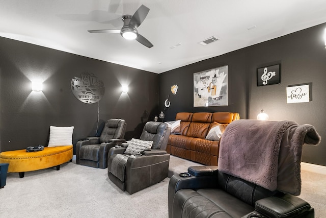 home theater room featuring ceiling fan and light carpet