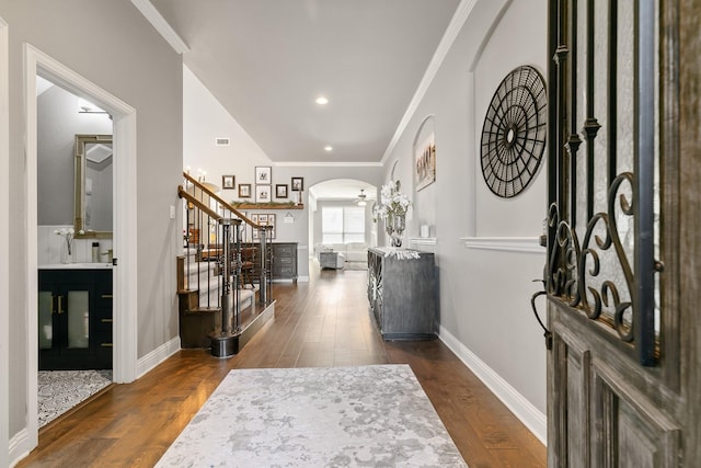 foyer with dark hardwood / wood-style flooring, crown molding, and ceiling fan